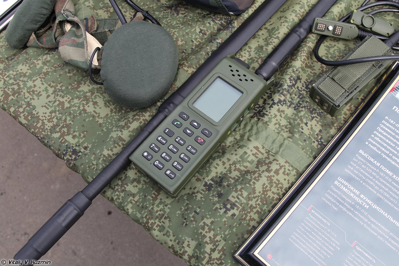 Radiostacja AZART R-187P1 w zielonej obudowie z klawiaturą numeryczną i małym wyświetlaczem, leżąca na wojskowej macie obok anten i mikrofonogłośnika